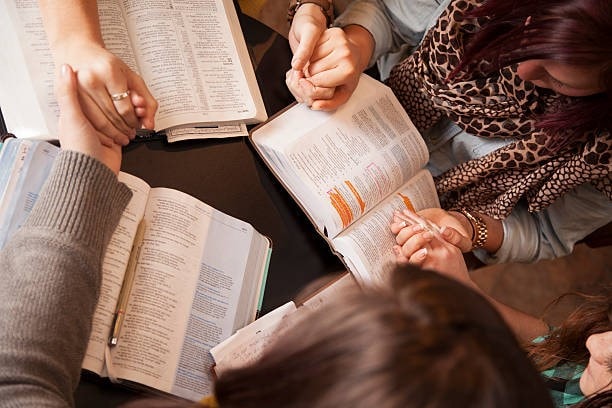 People studying open Bibles together